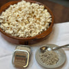 There is a bowl of pop corn with Omnivore 2 oz Tartufo Tin and a salt dish with Tartufo in it with a small silver spoon